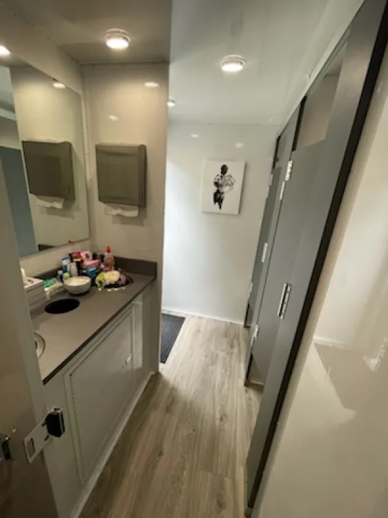 5-station double vanity with toiletries and gray privacy stalls