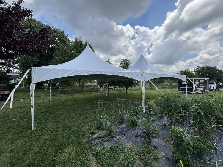 A Restroom Ranch 20 by 40 high peak tent, made of two 20 by 20 sections, set up on a backyard lawn